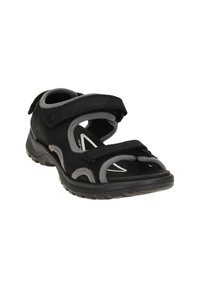 Schwarze Mehrfachriemen-Sandale mit Klettverschlüssen, oberer Teil aus Wildleder-ähnlichem Material, Gummisohle und grauen Akzenten an Kanten und Konturen.