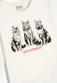 Biała bluza z kapturem z trzema wesołymi ilustracjami kotów w czarnych detalach, z napisem "ŻYCIE JEST PURRFECT" w różowym poniżej.