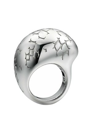 Anillo escultórico de plata con forma suave y redondeada que presenta patrones geométricos recortados que crean textura y contraste.
