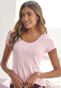 Light pink, short-sleeved top with scalloped neckline, featuring a textured striped pattern and small eyelet details throughout.