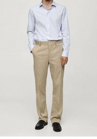 Lichtblauw button-up shirt met lange mouwen en kraag, gecombineerd met beige broek. Kenmerkt zich door een strak ontwerp, rechte snit en zwarte schoenen.