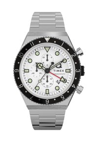 Timex chronograph laikrodis su sidabriniu nerūdijančio plieno dirželiu, baltu ciferblatu, juodu rėmeliu ir šviečiančiais žymekliais. Įranga apima subciferblatus ir datos rodymą.