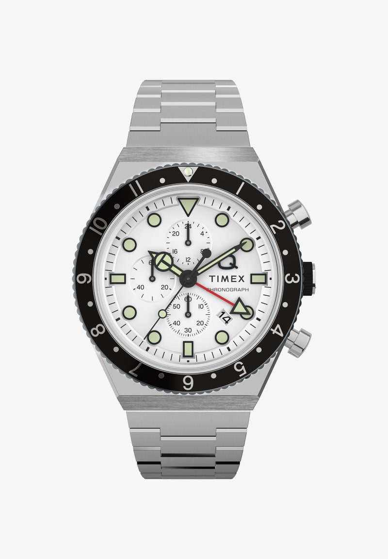 Timex kronografska ura s srebrnim pasom iz nerjavečega jekla, belim številčnico, črnim okvirjem in luminescentnimi oznakami. Ima podštevilčnike in prikaz datuma.