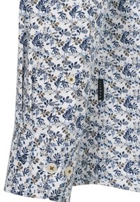 Weißes Hemd mit einem blauen und goldenen Blumenmuster. Verfügt über geknöpfte Manschetten und ein Etikett. Das Material wirkt glatt mit einem leichten Glanz.