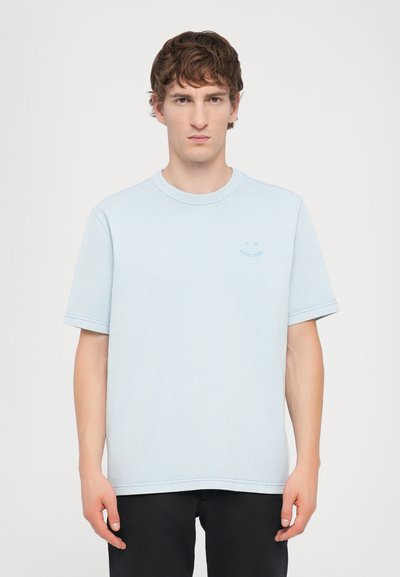 Helles blaues T-Shirt mit kurzen Ärmeln und Rundhalsausschnitt, das dezente Stickdetails und ein kleines Logo auf der linken Brust aufweist. Weicher Stoff.