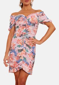 Blommig off-shoulder klänning med puffärmar, med en draperad design i nyanser av rosa, blått och grönt, och en hög-låg längd.