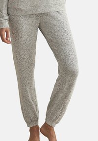 Pantalon de jogging gris à motifs, avec des poignets et une taille élastiques, fabriqué dans un tissu doux et texturé. Convient pour un style décontracté ou pour se détendre.
