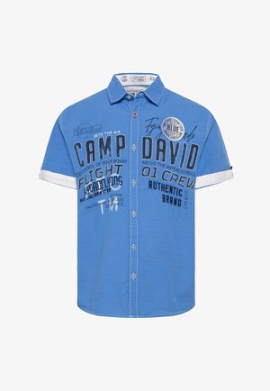 Kurzärmeliges blaues Hemd mit Knopfleiste, das verschiedene gedruckte Texte und Logos in Schwarz aufweist, weiße Bündchen und strukturierter Stoff.