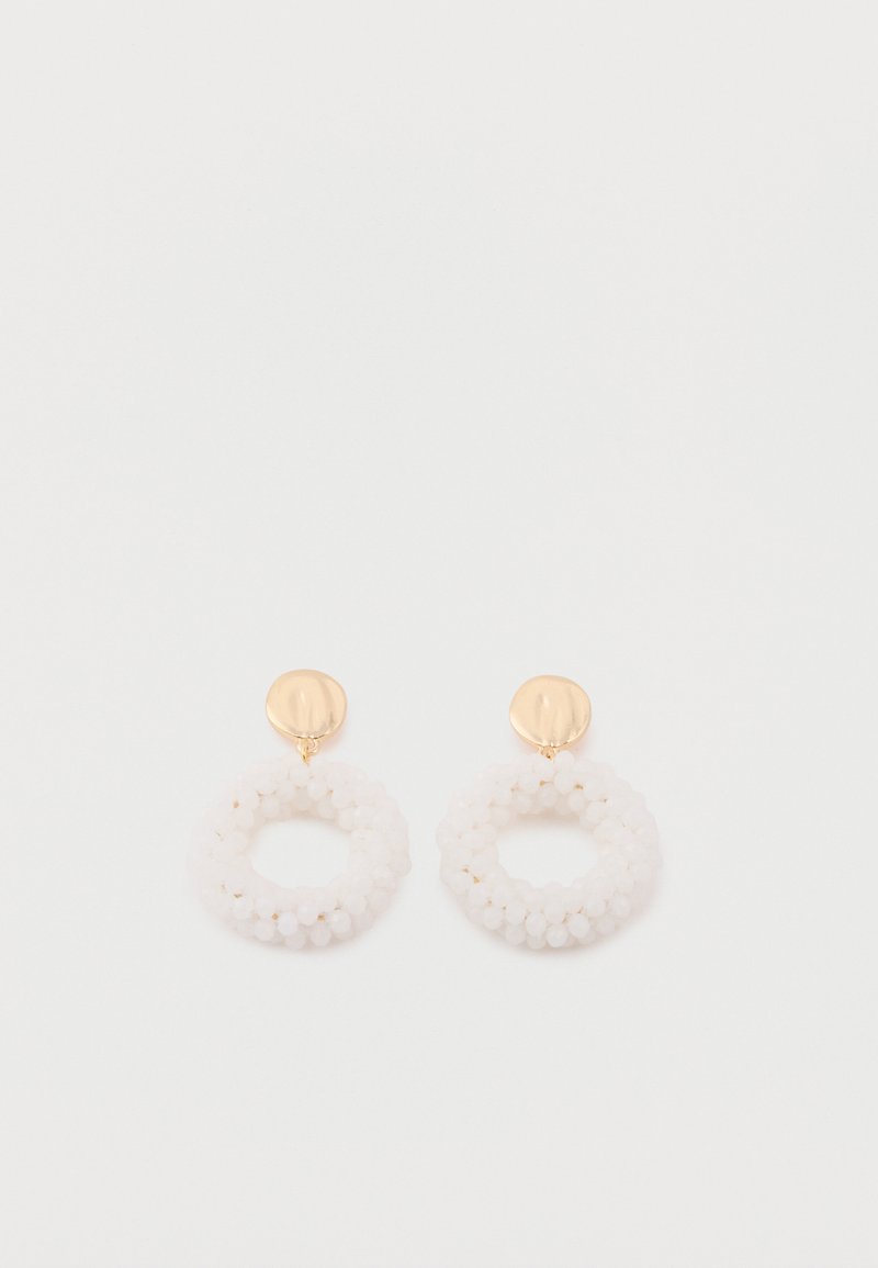 Χρυσά σκουλαρίκια μπουτόν με κυκλικές συστάδες από μικρές λευκές χάντρες που σχηματίζουν μια υφασμάτινη στεφάνη κρεμασμένη κάτω από κάθε μενταγιόν.