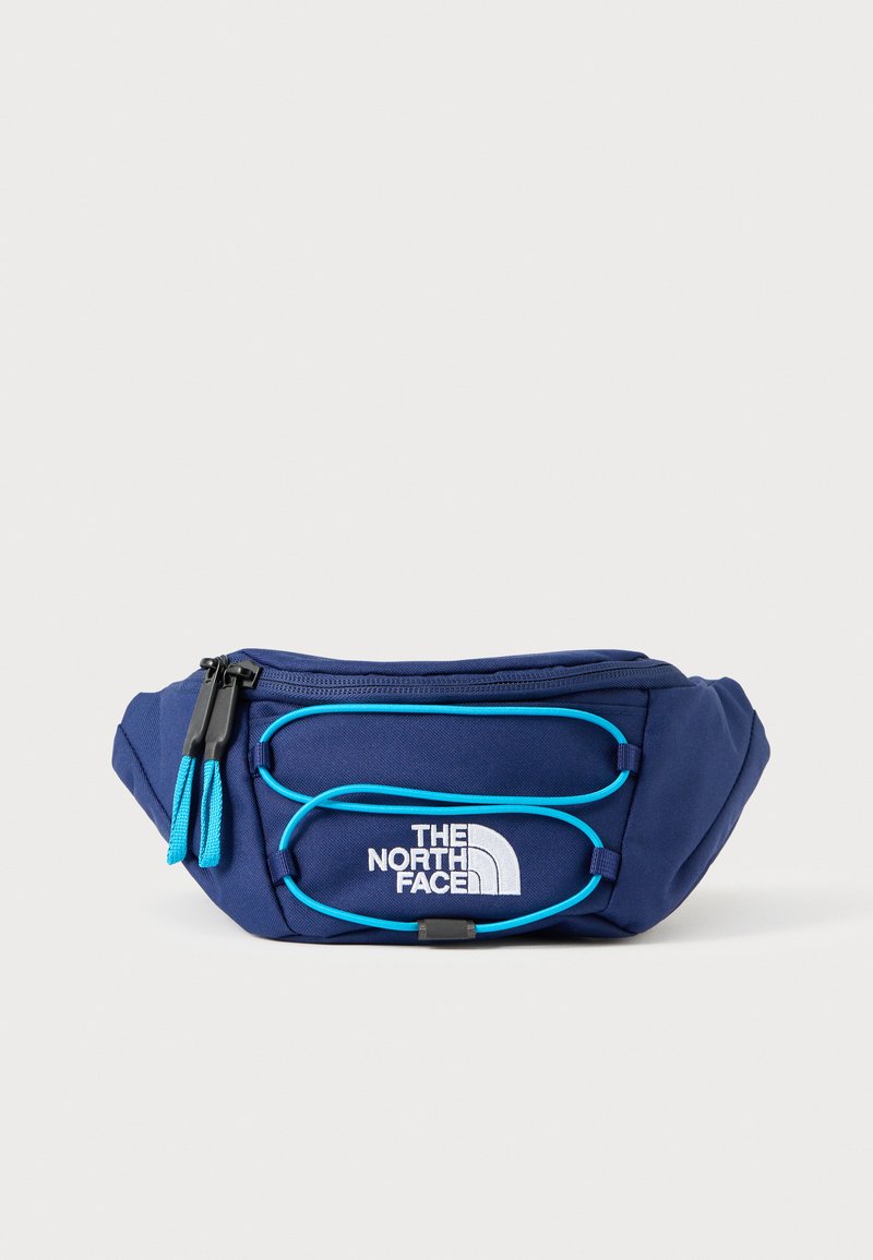 Ledvinka z tkaniny tmavě modré barvy s tyrkysovými detaily, logo na přední straně, zapínání na zip a design se dvěma přihrádkami. Texturovaný povrch s nastavitelným popruhem.