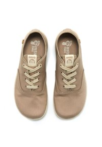 Sneaker in tela beige con lacci beige chiaro, punta arrotondata e superficie testurizzata. Logo visibile sulla linguetta e sulla soletta.
