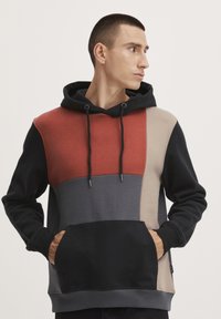 Hodie med hette med fargeblokkdesign i røde, grå, beige og svarte seksjoner. Inkluderer kenguru-lomme og snor.