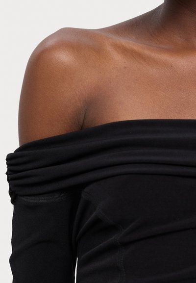 Schwarzes Off-Shoulder-Oberteil aus weichem Stoff, mit einem gerafften Design am Ausschnitt und nahtlosen langen Ärmeln.