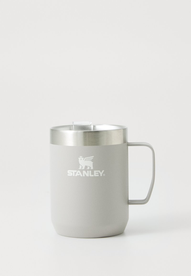 Copo de aço inoxidável com um acabamento mate cinza, pega ergonómica e uma borda prateada. Apresenta um logótipo impresso na frente.