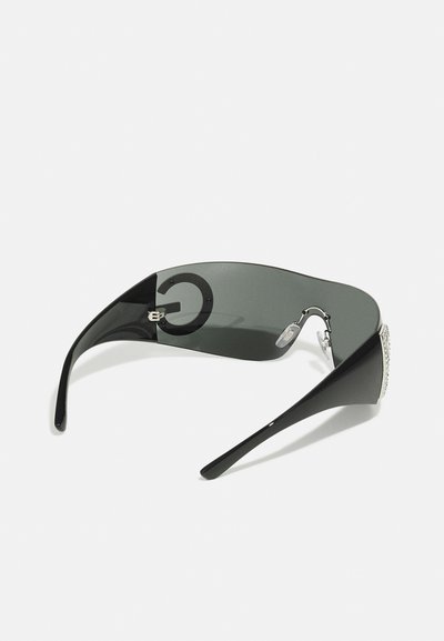 Black sunglasses with a curved gray lens, logo detail on the side, sleek arms, and accentuated by rhinestones on the outer edges.