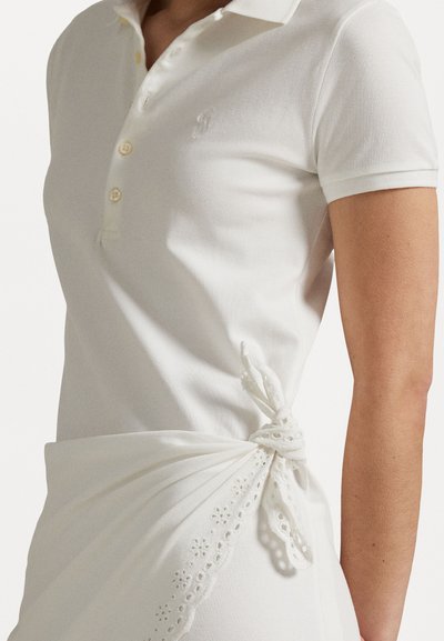 Weißes Poloshirt aus strukturiertem Stoff mit einer Knopfleiste mit drei Knöpfen und gesticktem Logo. Ein gedrehter Stoffakzent mit feinen Spitzenverzierungen.