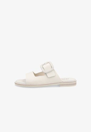 Sandalia plana blanca con tira frontal ancha y gran hebilla cuadrada en la tira superior, suela clara con diseño sutil en capas.