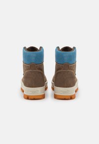 Botas de ante marrón con un cuello de ante azul y suela de goma naranja, que presentan un diseño simple y detalles de costura para dar estructura.