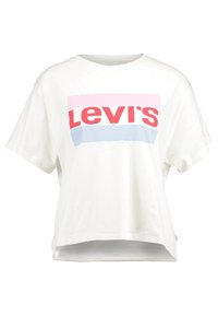 Valkoinen lyhythihainen T-paita, jossa on vaaleanpunaisia ja sinisiä vaakaraitoja sekä suuri punainen "Levi's" -logo keskellä etuosaa.