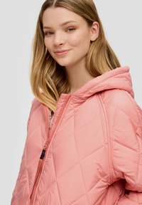 Gepolsterte Steppjacke in zartem Rosa mit Kapuze, ausgestattet mit einem Reißverschluss und diagonaler Nähtechnik. Sanfte, leichte Textur.