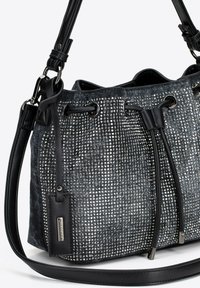 Zwarte emmer tas van gestructureerde stof met zilveren studs, trekkoordsluiting en een afneembare leren schouderband. Gestructureerde zijkanten en een gladde bodem.