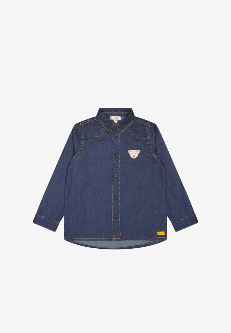Chemise en denim bleu foncé à manches longues avec boutons sur le devant, surpiqûres jaunes et petite écusson nounours sur le côté gauche de la poitrine.
