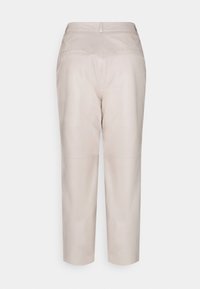 Helle beige Lederhosen mit geradem Schnitt, mittelhoher Taille, zwei Gesäßtaschen und minimalen Nähten. Glatte Textur.