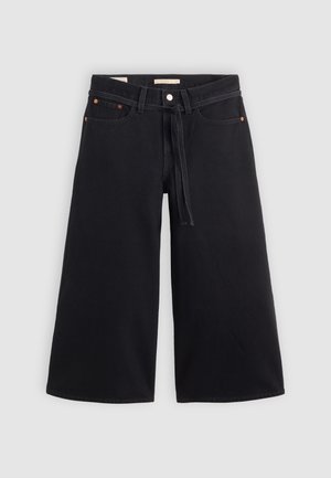 Black wide-leg denim trousers feature a drawstring waist, belt loops, copper accents, and a clean finish. Fabric is sturdy and textured.