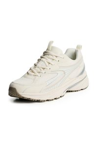 Tenisky v smotanovej farbe s textúrovaným sieťovinovým zvrškom, reflexnými akcentmi, polstrovanou podrážkou a robustnou gumovou podrážkou.