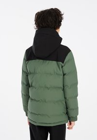 Giubbotto imbottito con corpo verde e pannello spalle nero, dotato di cappuccio, polsini elasticizzati e texture trapuntata per l'isolamento.