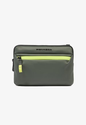 Rechteckiges olivgrünes Täschchen mit hellgelbem Reißverschluss vorne und schwarzem Markenlogo, das zentriert über der Tasche angebracht ist.