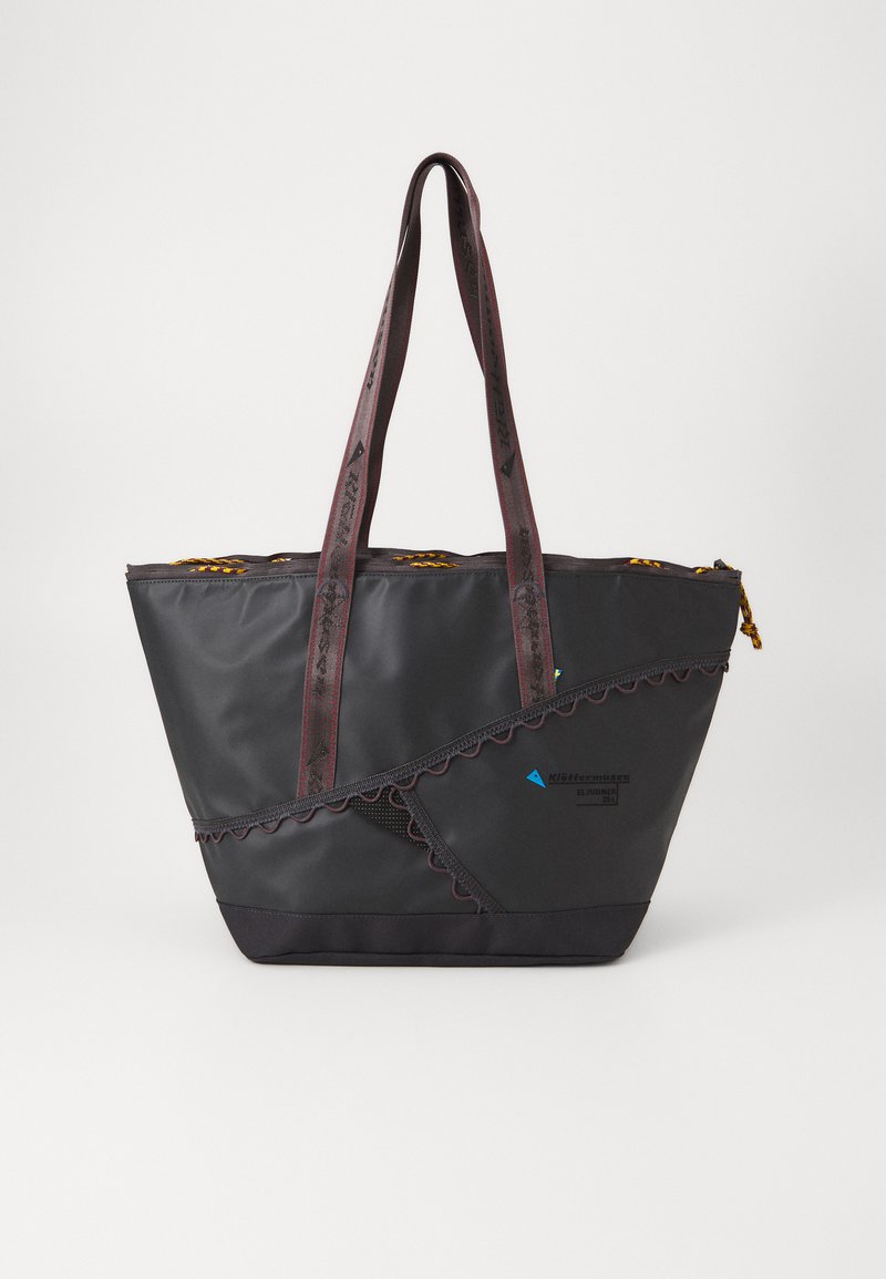 Sac fourre-tout noir avec un design à volants, doté de poignées rouges, d'un revêtement texturé et d'un détail de logo. Comprend une fermeture à glissière et des accents dorés.