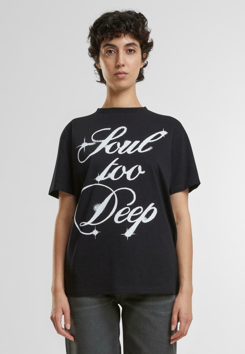 Camiseta de algodón negra de manga corta, con el texto en blanco, en negrita y estilizado "Soul too Deep" en el frontal. Cuello clásico tipo crew.