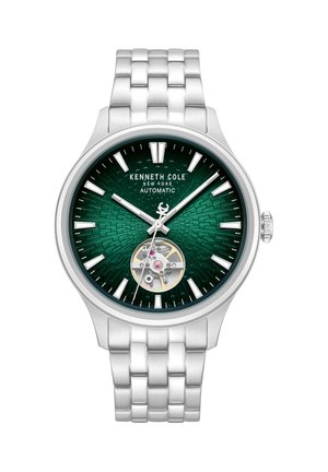 Kenneth Cole zilverkleurig metalen horloge met een groene gestructureerde wijzerplaat, witte uurmarkeringen, zichtbare automatische beweging op 6 uur en drie wijzers die 10:08:07 aangeven.