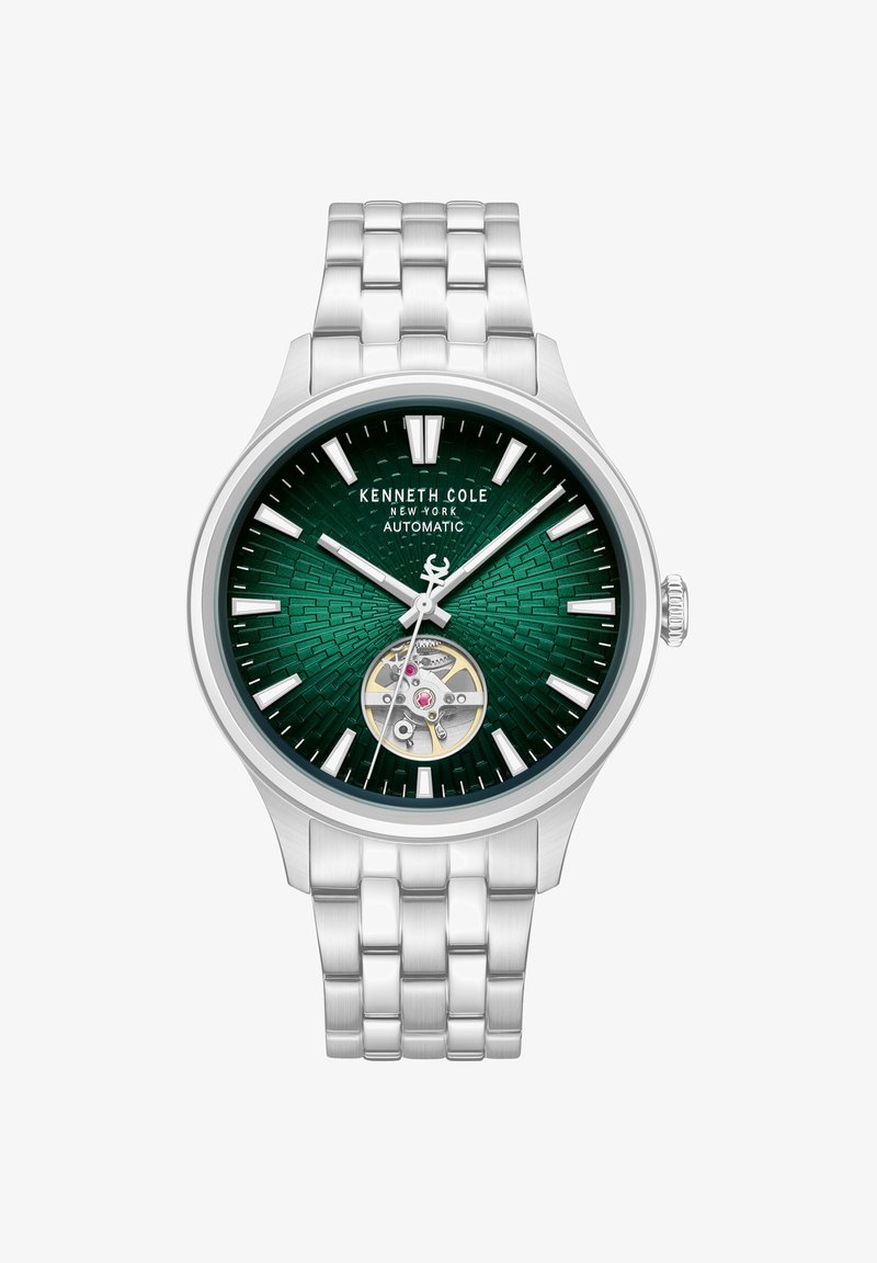Kenneth Cole zilverkleurig metalen horloge met een groene gestructureerde wijzerplaat, witte uurmarkeringen, zichtbare automatische beweging op 6 uur en drie wijzers die 10:08:07 aangeven.