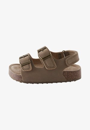 Sandale marron avec deux sangles réglables à boucle, semelle en liège, dessus texturé et semelle en caoutchouc, conçue pour le confort et la stabilité.