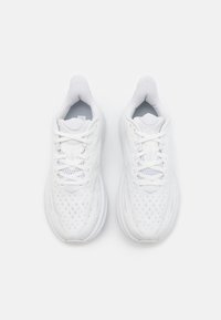 Vita träningsskor med ovandel i mesh, strukturerade detaljer och vadderade sulor. Har plana snören och en rund tådesign.