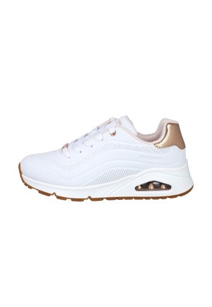 Zapatilla deportiva blanca con detalles en oro rosa, perforaciones, suela acolchada y cámara de aire visible en el talón.