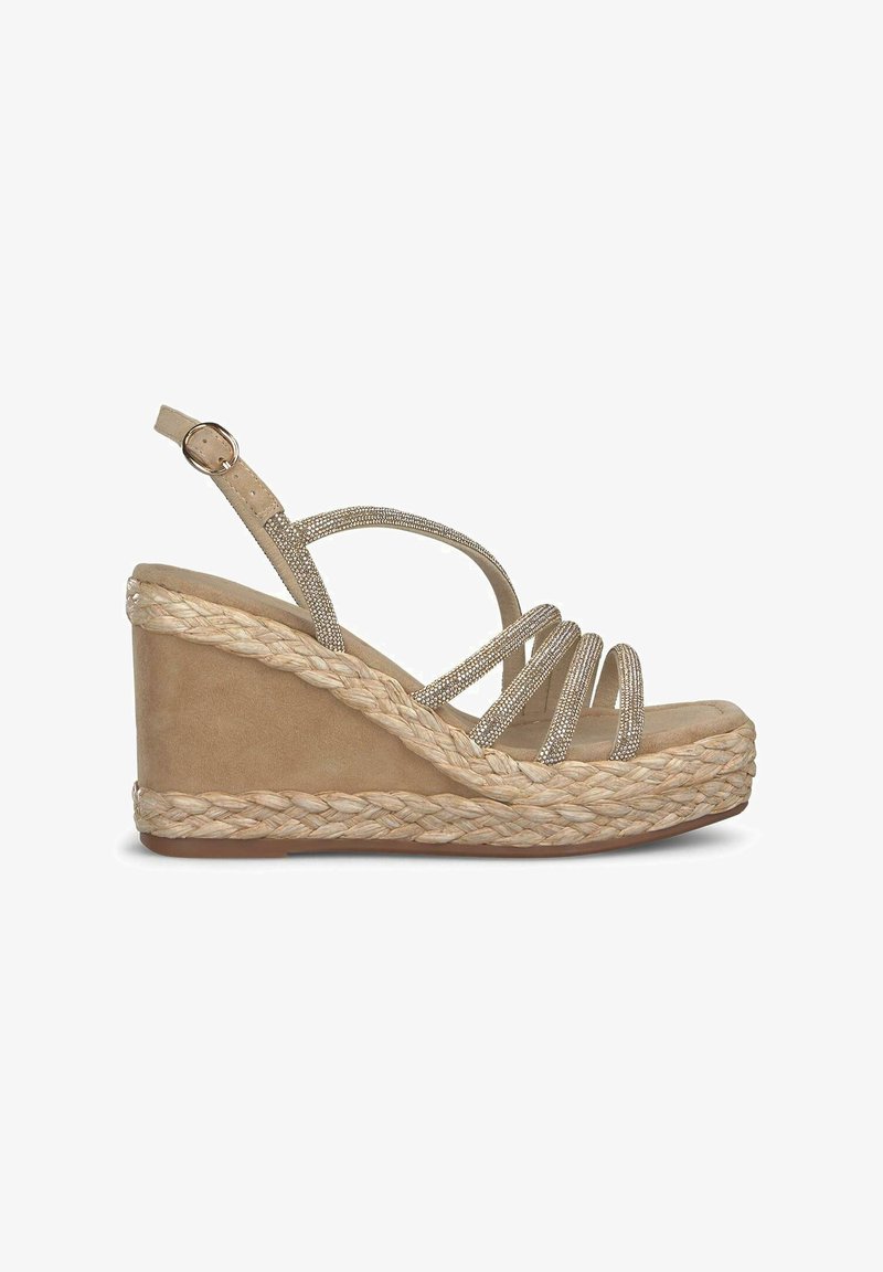 Beige wedge sandaal met gevlochten jute zool, voorzien van meerdere dunne banden versierd met zilveren embellishen en een gesp sluiting rond de enkels.