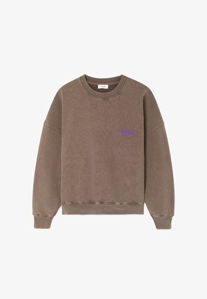 Pruun dressipluus ümarate kaelustega, ribaga varrukate ja servadega. Rinnal on väike lilla logo. Valmistatud pehmest, tekstuuriga kangast.