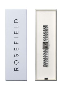 Reloj de cadena plateado con una esfera octagonal gris, alojado en una caja blanca con "ROSEFIELD" impreso en negro. Pulsera de reloj texturizada y diseño minimalista.