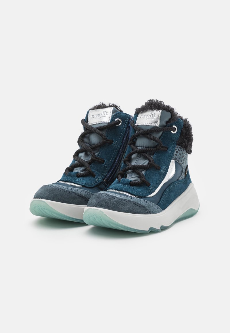 Blaue Wildleder-Hochtopfschuhe mit schwarzen Schnürsenkeln, einem gepolsterten Kragen, metallischen Akzenten und einer durchsichtigen Gummisohle; strukturierte Seiten für besseren Halt.