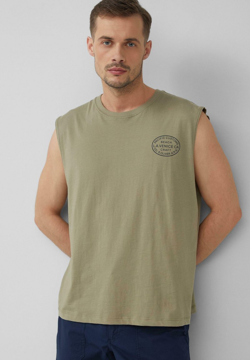 T-shirt sans manches vert olive en coton, avec un logo circulaire en impression foncée sur la poitrine. Coupe décontractée avec un col ras du cou.