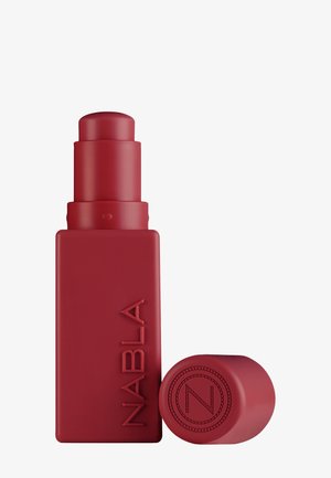 Rotes mattes rechteckiges Lippenstiftröhrchen mit auf der Seite eingeprägtem "NABLA" und einem runden Deckel mit einem runden Logo daneben liegend.