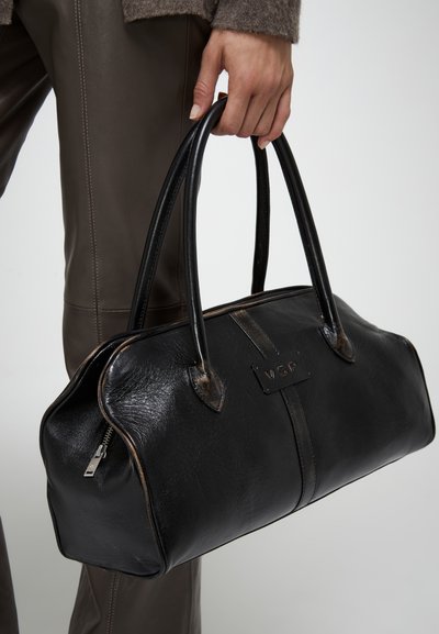Borsa in pelle nera di forma arrotondata, con due manici lunghi, chiusura con cerniera e un'etichetta rettangolare stampata con "VSP". Texture liscia, accenti minimi.