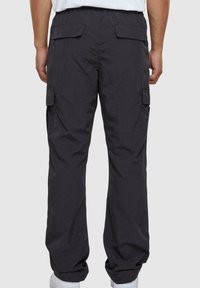 Black cargo pants with a relaxed fit, made of lightweight fabric. Features two side pockets and two back pockets. Elastic waistband.