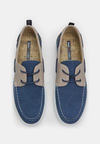 Scarpe da barca in tela blu navy con dettagli beige, design con lacci, cuciture bianche a contrasto e interno in sughero. Suola in gomma.
