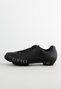 Zapato de ciclismo Giro negro con un diseño elegante, parte superior perforada, cordones tradicionales y suela Vibram para una mayor tracción.