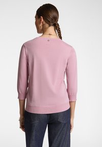 Maglione rosa lavorato a maglia con maniche a tre quarti, orlo e scollatura a costine. Texture morbida con un delicato dettaglio scintillante sul retro.