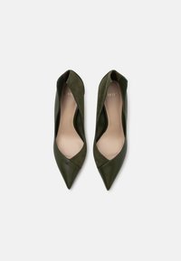 Zapatos de tacón alto verde con punta afilada, hechos de cuero y ante, con un diseño recortado y un acabado de textura suave.